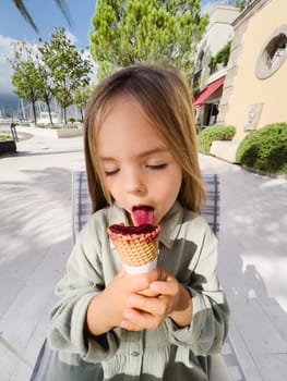 Little girl licks popsicles in a cone. High quality photo