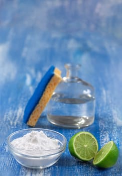 Baking soda, vinegar and cut lemons on white wooden table, flat lay.