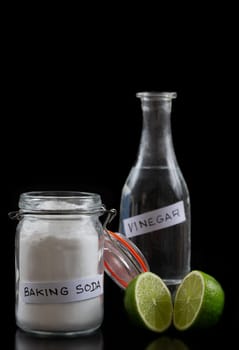 Baking soda, vinegar and cut lemons on blac table, flat lay. Space for text