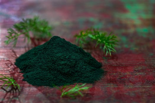 Organic green spirulina powder top view wooden background. Super foods, food supplement