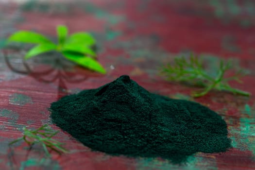 Organic green spirulina powder top view wooden background. Super foods, food supplement