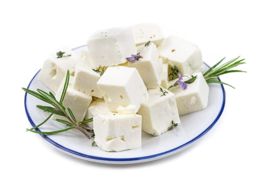 Feta cheese cubes isolated on white background with clipping path. Heap of Feta cheese, basil leaves and tomatoes.