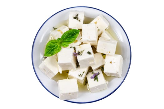 Feta cheese cubes isolated on white background with clipping path. Heap of Feta cheese, basil leaves and tomatoes.