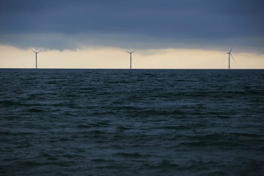 Wind turbines in the North Sea in Denmark in the evening.