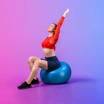 Full body length gaiety shot athletic and sporty young woman with fitness exercising ball in standing posture on isolated background. Healthy active and body care lifestyle.