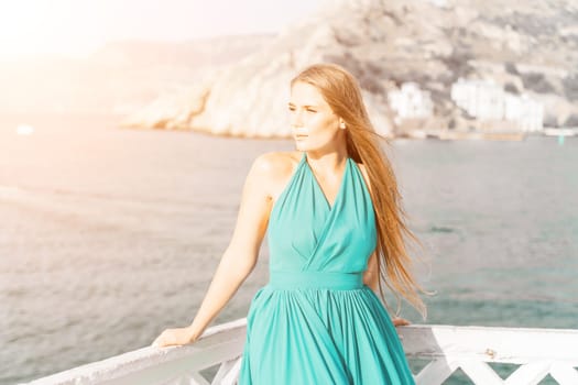 Woman sea trevel green dress. Side view a happy woman with long hair in a long mint dress posing on a beach with calm sea bokeh lights on sunny day. Girl on the nature on blue sky background