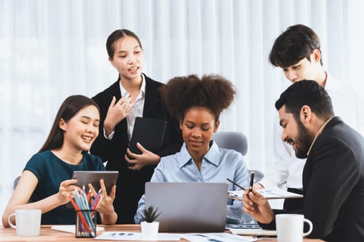 Multiracial analyst team use BI dashboard data to analyze financial report on meeting table. Group of diverse business people utilize data analysis by FIntech for success business marketing. Concord