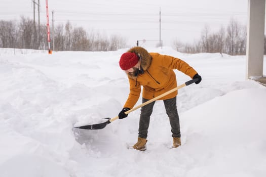 Man is clearing the snow near house and on staircases hovelling at the winter season. Winter storm and season specific.