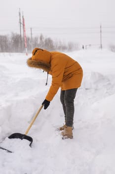 Man is clearing the snow near house and on staircases hovelling at the winter season. Winter storm and season specific.