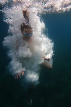 Underwater view of a swimmer with goggles amidst a burst of air bubbles