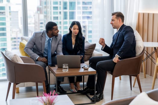 African businessman present start up project to expert investor. Group of multicultural business team solving problems, discussing business idea with skyscraper at modern business lounge. Ornamented