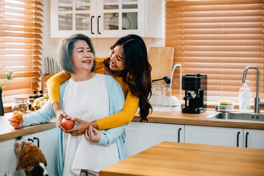 In the kitchen, an old mother receives a loving embrace from her cute young daughter. This heartwarming portrait captures the essence of family togetherness and care.