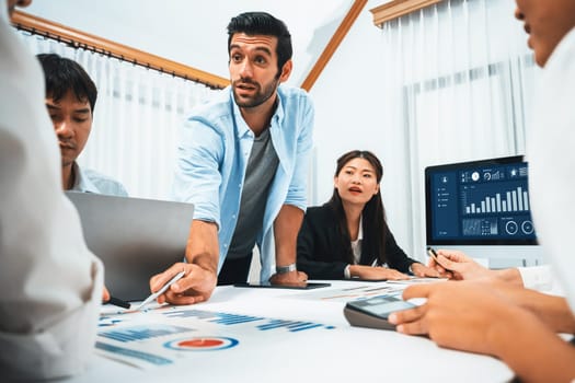 Analyst team utilizing BI Fintech to analyze financial data at table in meeting room. Businesspeople analyzing BI dashboard power for business insight and strategic marketing planning. Prudent