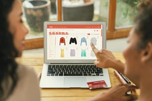 Woman shopping online on internet marketplace browsing for sale items for modern lifestyle and use credit card for online payment from wallet protected by crucial cyber security software