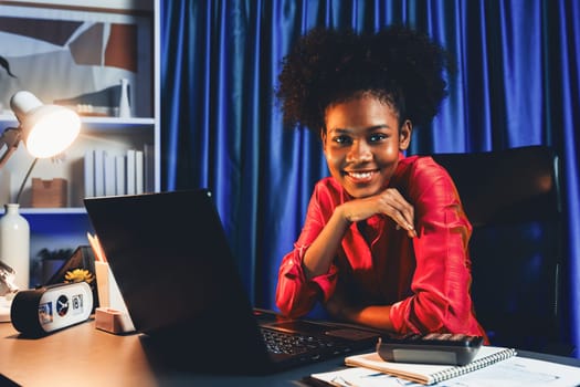 Working African woman with happy glowing, smiling face, getting new job project with good deal or marketing course scholarship information on laptop screen. Concept of cheerful expression. Tastemaker.