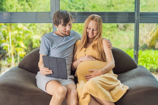A smiling husband and his pregnant wife share a moment of joy, gazing at a tablet screen, their faces glowing with anticipation and happiness.
