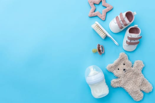 Essential items for newborn care elegantly displayed on a vibrant blue background, flat lay