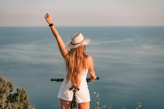 A woman cyclist on a mountain bike looking at the landscape sea. Adventure travel on bike