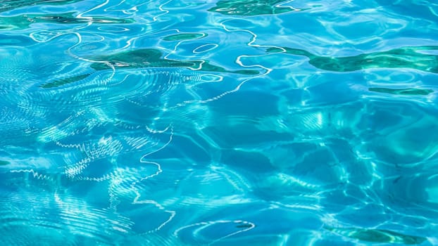 Turquoise sea waves in sunshine glow as surface background. Summer holidays and coastal nature concept