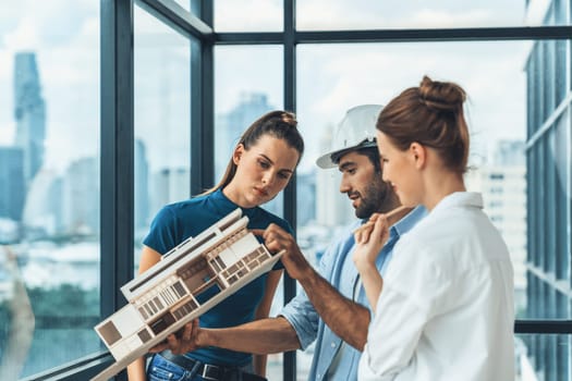 Smart engineer holds house model and explain about house construction to skilled manager. Group of interior designer inspect architectural model. Working together, Civil engineering. Tracery.