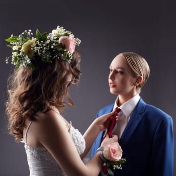 Gay wedding. Pretty bride straightens groom's tie