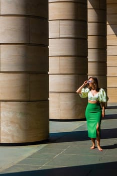 woman is resting after work, modern architecture, beige columns in business center or office building. urban. full-length photo. High quality photo