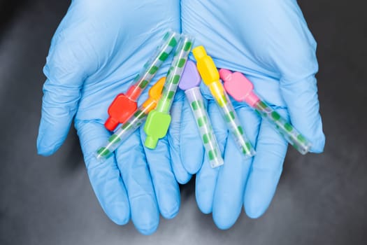 Close up Interdental Toothbrushes in dentists hands in rubber gloves on black background.