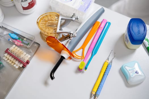 Dental tools, brushes, model jaw on the table in dentist office.