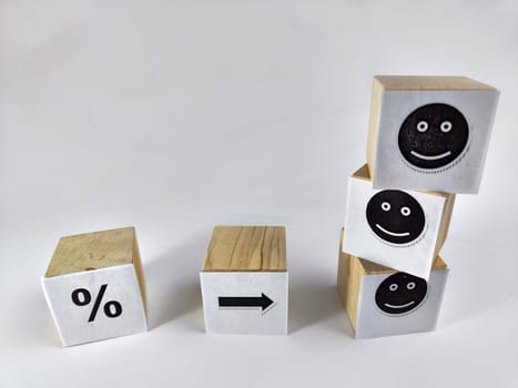 Wooden cubes in a column and row with white signs with a smiley sign, a percentage. The concept of positivism. Efforts and achievements lead to pleasure, joy, positivism and positive thinking