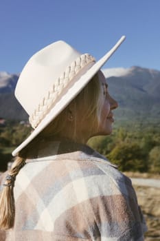 Closeup photo of a young woman enjoying and contemplating the mountains
