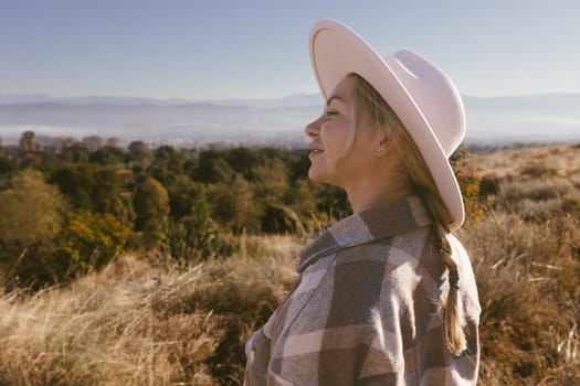 Closeup photo of a young woman enjoying and contemplating the mountains