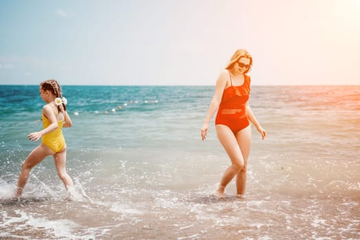 Happy loving family mother and daughter having fun together on the beach. Mum playing with her kid in holiday vacation next to the ocean - Family lifestyle and love concept.
