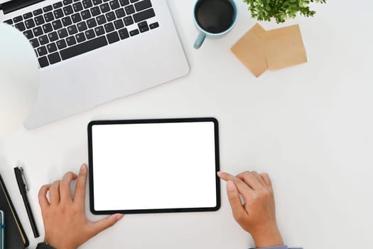 Young businesswoman using digital tablet on white office desk. Top view, Flat lay.