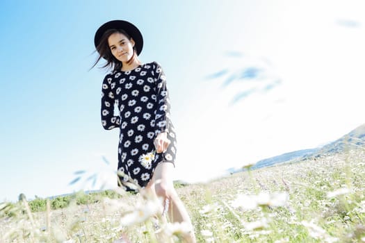 Beautiful woman in field in flowers in nature walk chamomile journey