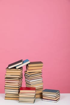 stack of books on a pink background in the library cabinet education training