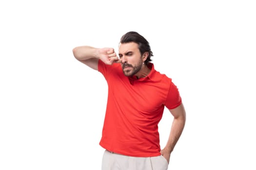 young confused man with black hair and beard dressed in a red corporate t-shirt.