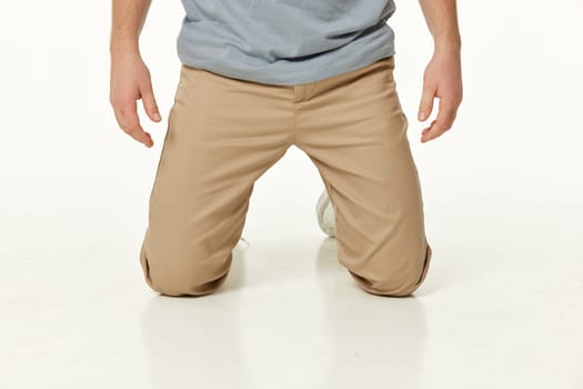 casual man standing on his knees on white studio background