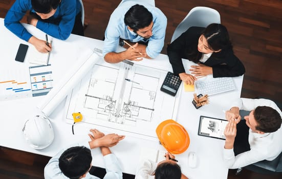 Top view banner of diverse group of civil engineer and client working together on architectural project, reviewing construction plan and building blueprint at meeting table. Prudent