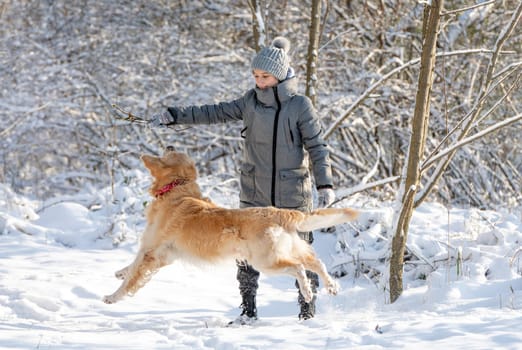 Girl, Teenager, And Golden Retriever Joyfully Play With Snow In Winter Forest