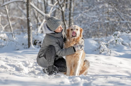 Girl, Teenager, And Golden Retriever Joyfully Play With Snow In Winter Forest