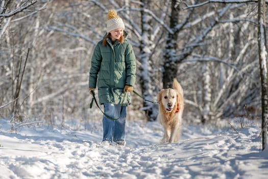 Girl Walks With Golden Retriever In Winter Forest, Strolling With Dog Through Snow-Covered Woods