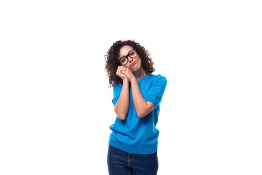 authentic slim young caucasian woman with curls dressed in a blue t-shirt and jeans.