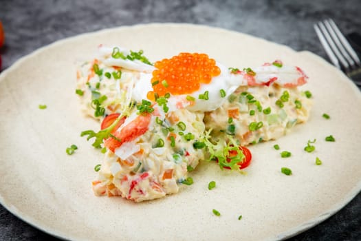 salad with mozzarella, caviar and green onions on a white plate