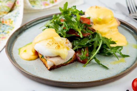 breakfast of arugula and tomato, toast with cheese and poached egg