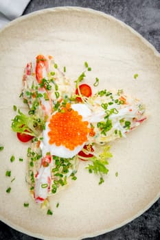 salad with mozzarella, caviar and green onions on a white plate