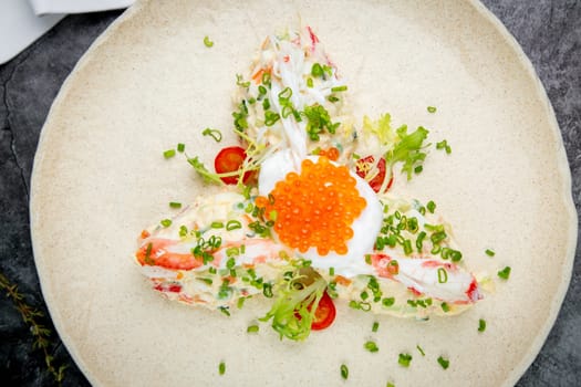 salad with mozzarella, caviar and green onions on a white plate