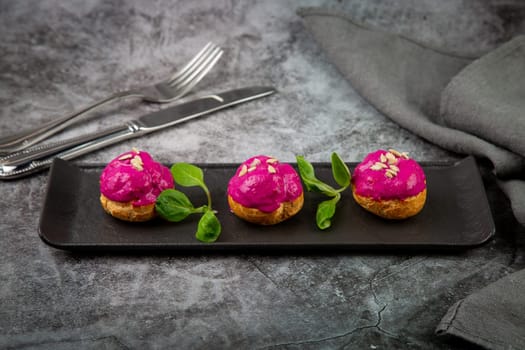 dessert of baked buns with raspberry topping and seed decorations