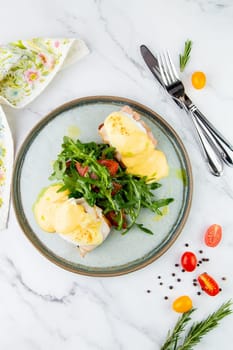 breakfast of arugula and tomato, toast with cheese and poached egg