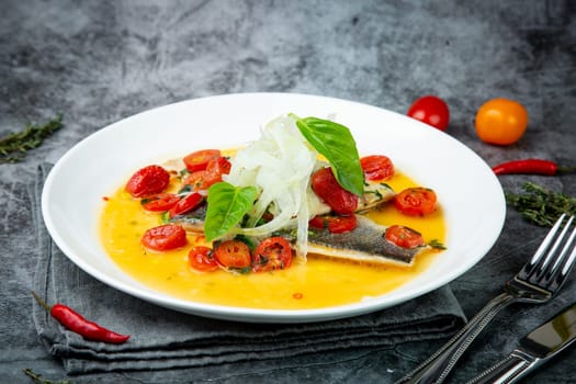 unpeeled fish with gravy, herbs, cherry tomatoes and onions