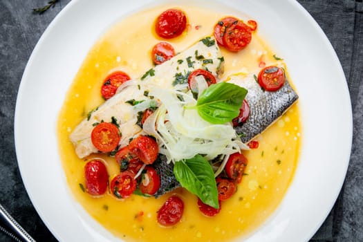 unpeeled fish with gravy, herbs, cherry tomatoes and onions